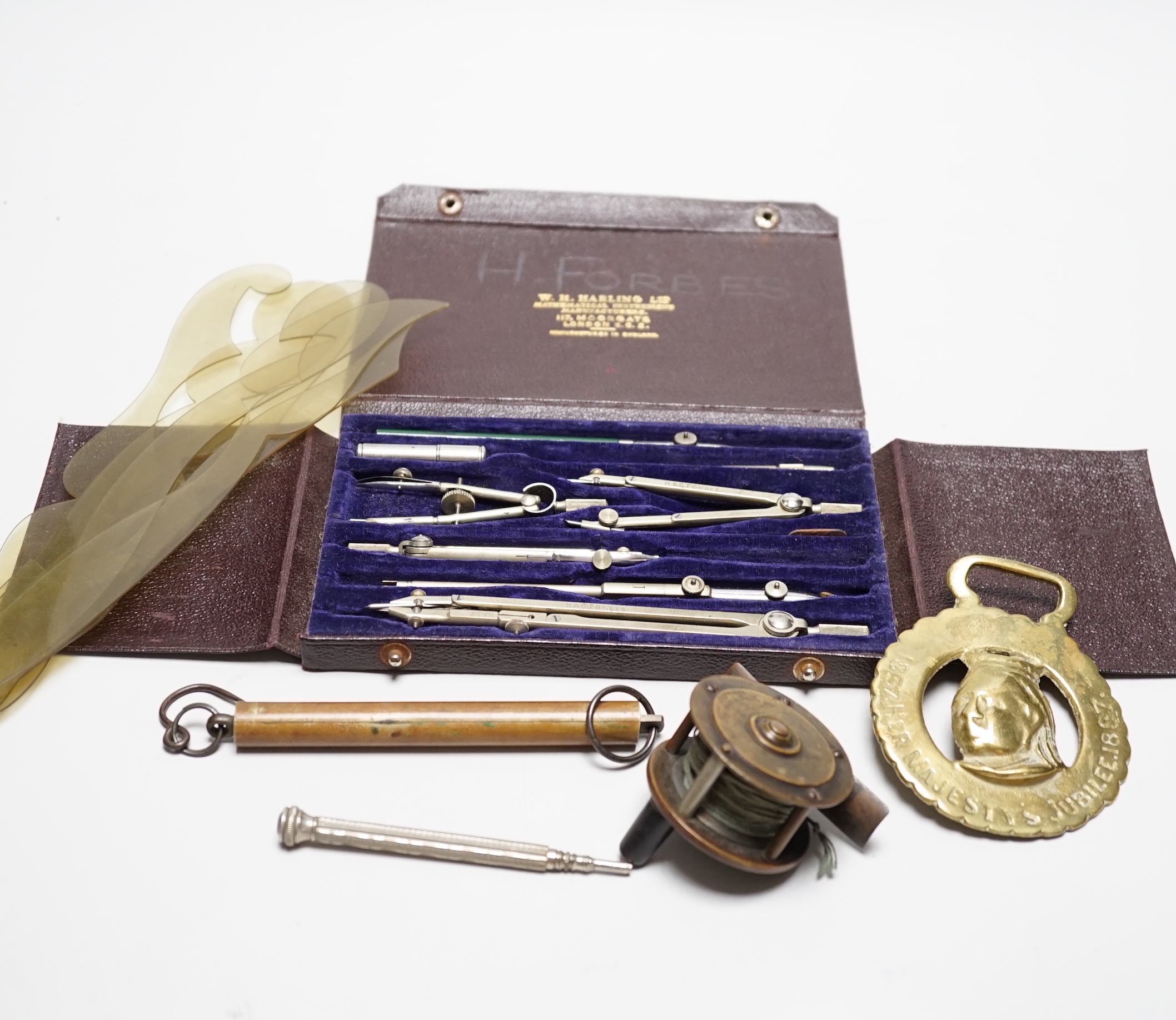 A mixed group of collectables including a commemorative bottle opener, shooting medallion, fishing reel etc.